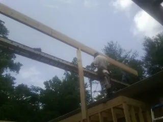 Carpenter setting a ridge beam over a new addition frame — Ice Dam Removal by Roofing Brothers in Glenbrook