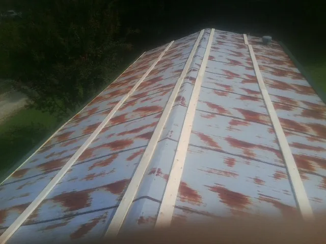 Rusted metal roof panels with new wood purlins before replacement — Storm Damage Roof Repair in Glenbrook by Roofing Brothers